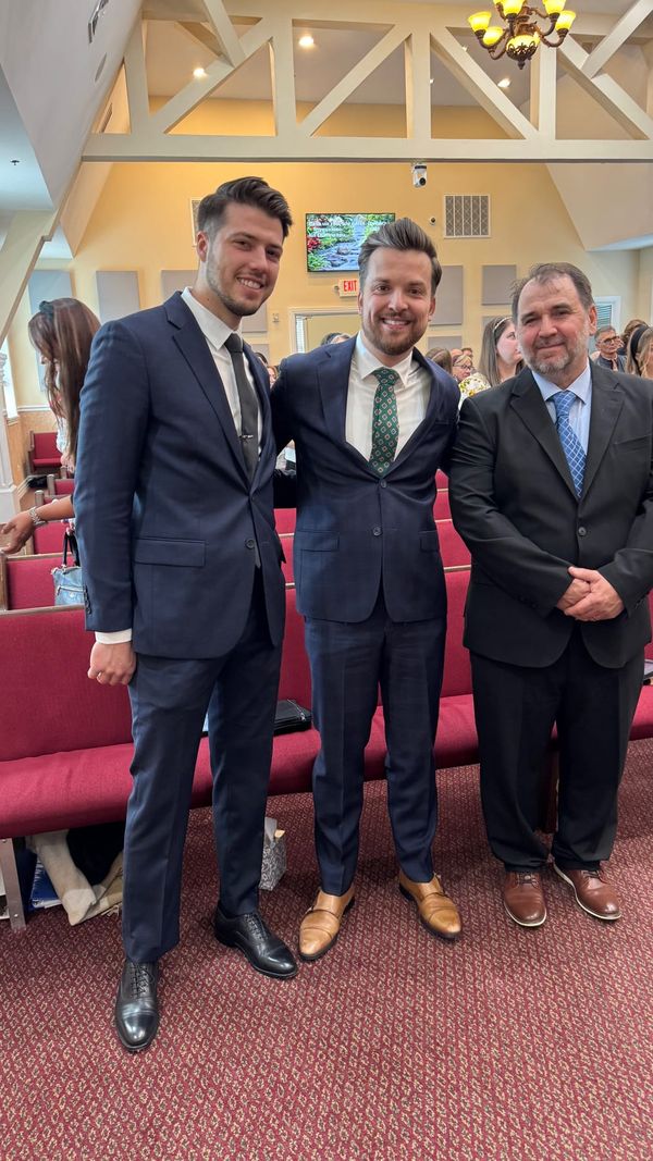 Three ministers in suits smiling together