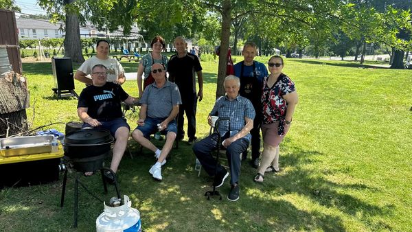 Friends gathered in the shade on a sunny lawn
