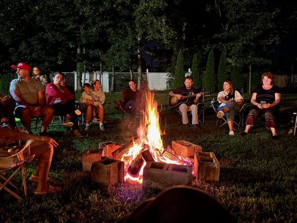 People gathered around the glowing campfire